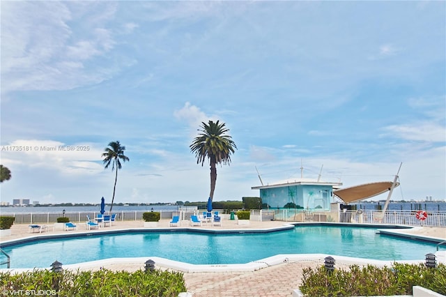 pool with a patio area and fence