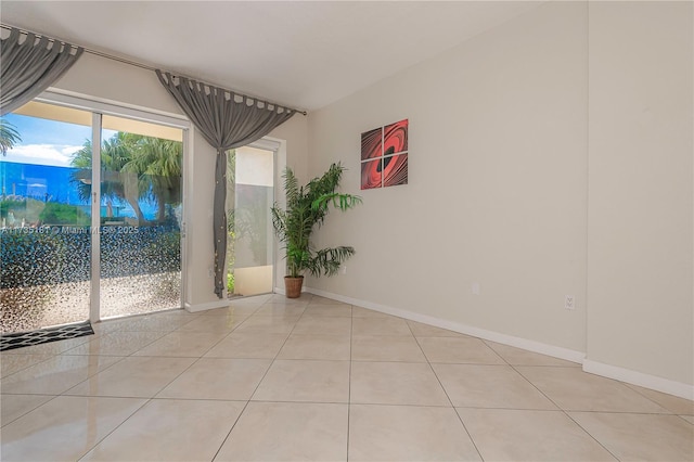 spare room featuring baseboards and light tile patterned flooring