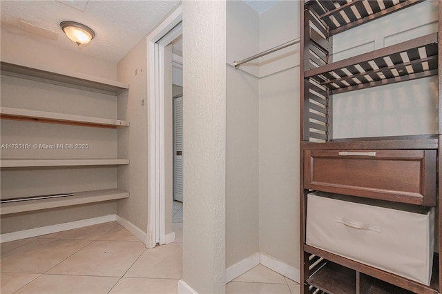 spacious closet featuring light tile patterned floors