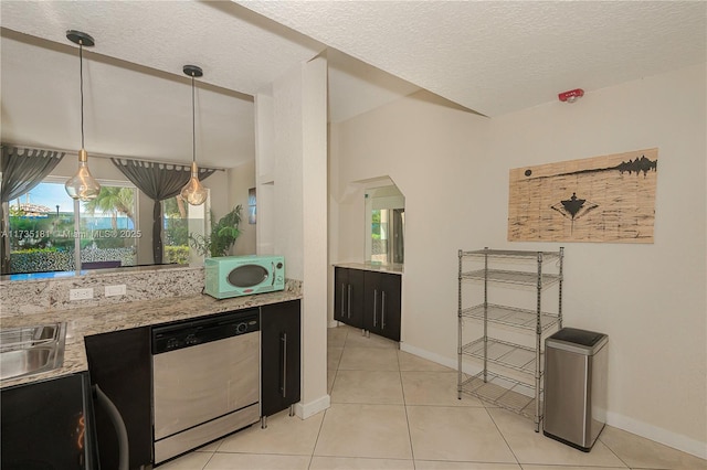 kitchen featuring a textured ceiling, white microwave, light tile patterned flooring, dark cabinetry, and dishwasher