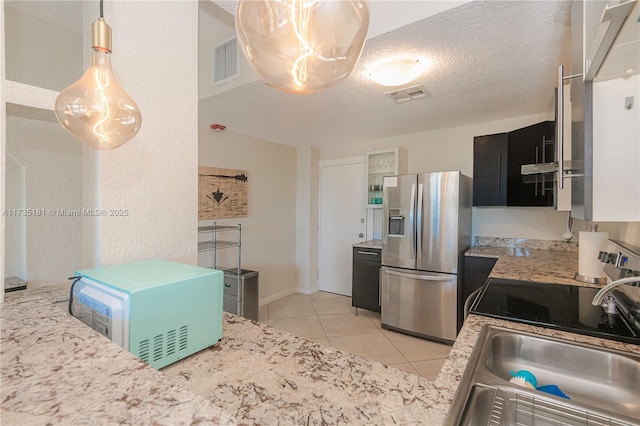 kitchen with a textured ceiling, a sink, visible vents, and stainless steel fridge with ice dispenser