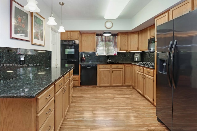 kitchen with sink, hanging light fixtures, tasteful backsplash, black appliances, and light hardwood / wood-style floors