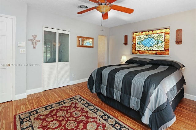 bedroom featuring ceiling fan, baseboards, and wood finished floors