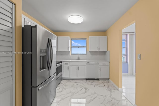 kitchen featuring white cabinetry, appliances with stainless steel finishes, sink, and backsplash