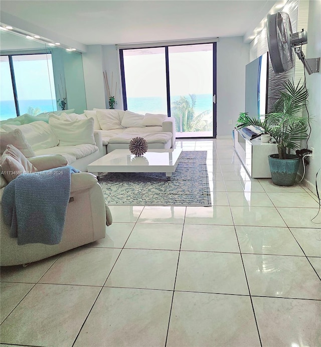 living room with a healthy amount of sunlight, tile patterned floors, and a wall of windows