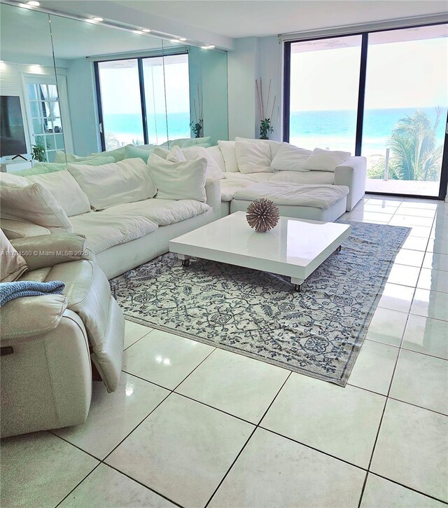 living room with a water view, plenty of natural light, and light tile patterned floors