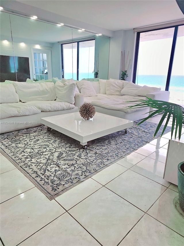 living room with light tile patterned floors and a water view