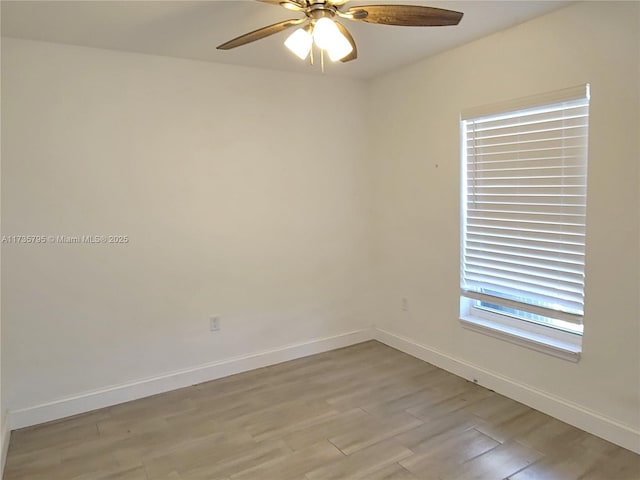 empty room featuring light wood finished floors, baseboards, and a ceiling fan