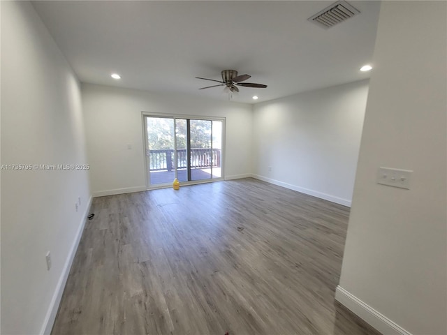 empty room with recessed lighting, visible vents, baseboards, and wood finished floors