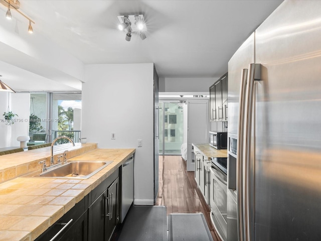 kitchen with appliances with stainless steel finishes, sink, and dark hardwood / wood-style floors