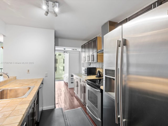 kitchen featuring tasteful backsplash, appliances with stainless steel finishes, sink, and dark hardwood / wood-style floors