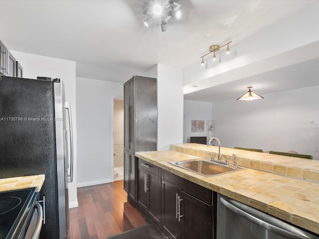 kitchen featuring stainless steel appliances, dark hardwood / wood-style flooring, sink, and dark brown cabinets