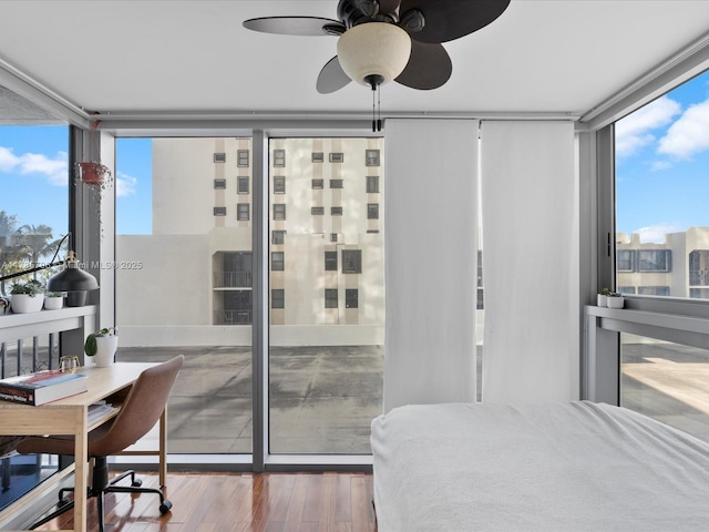 bedroom with expansive windows, wood-type flooring, and multiple windows