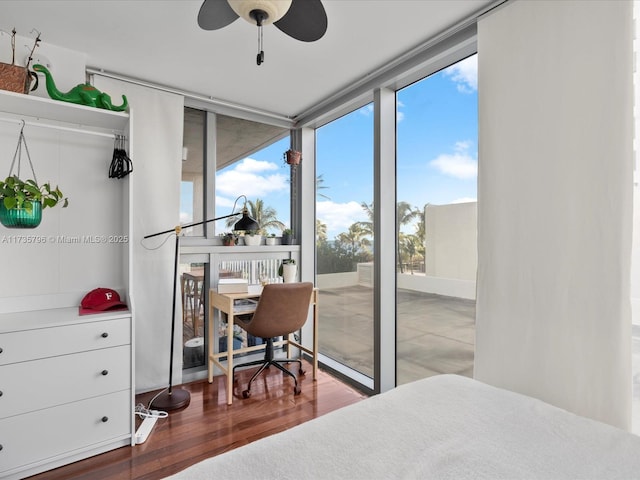 bedroom featuring a wall of windows and hardwood / wood-style floors