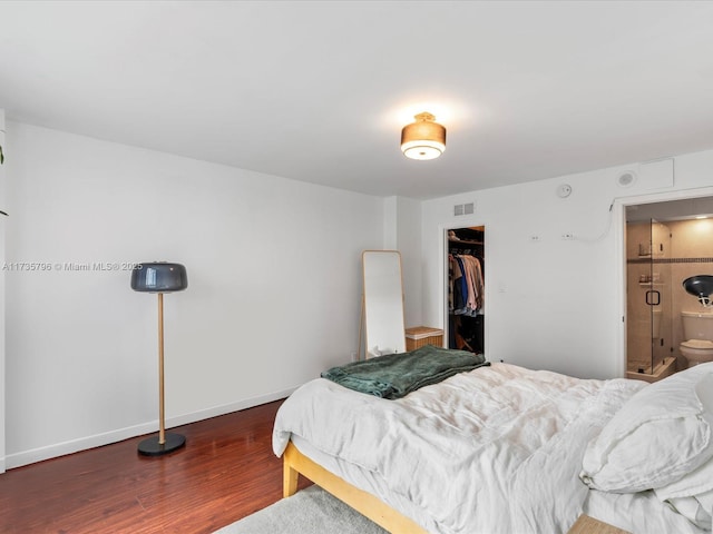 bedroom featuring ensuite bathroom, dark hardwood / wood-style floors, a closet, and a spacious closet