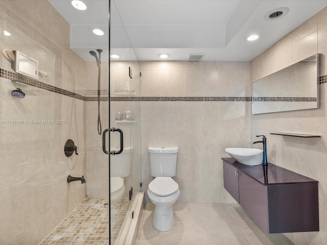 bathroom featuring an enclosed shower, tile walls, tile patterned floors, and toilet