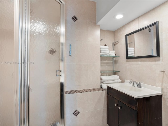 bathroom featuring vanity, tile walls, and walk in shower