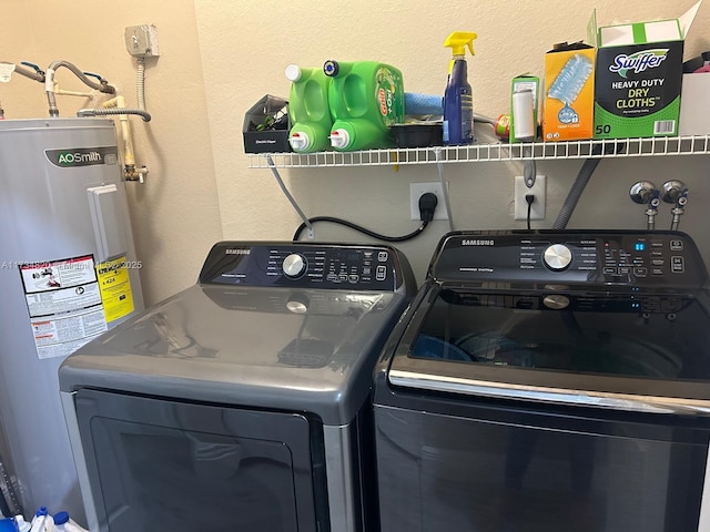 clothes washing area featuring electric water heater and washer and dryer