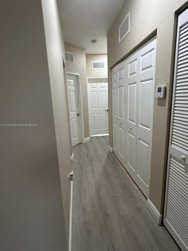 hallway with light hardwood / wood-style floors