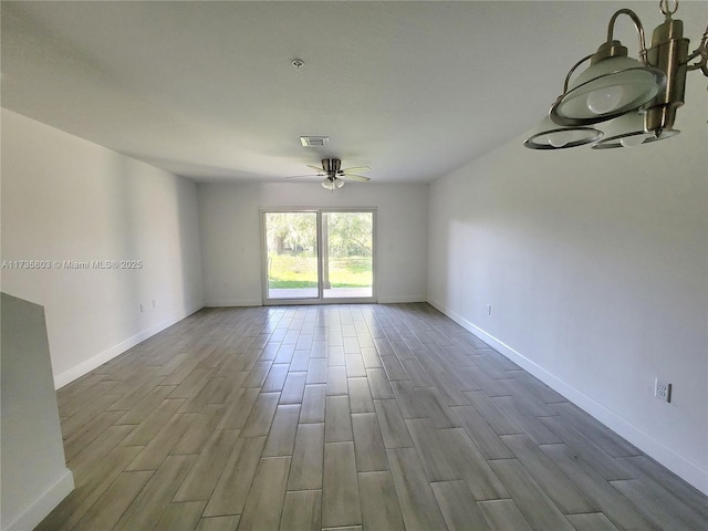 spare room with wood finish floors, visible vents, ceiling fan, and baseboards