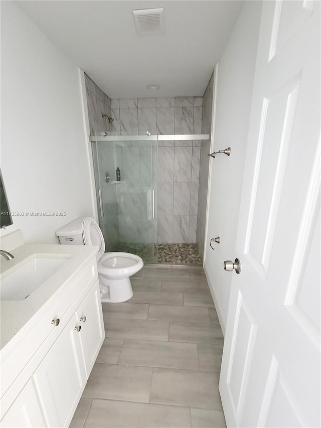 bathroom with visible vents, a marble finish shower, vanity, and toilet