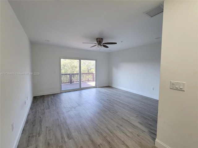 spare room with light wood-style flooring, a ceiling fan, visible vents, and baseboards