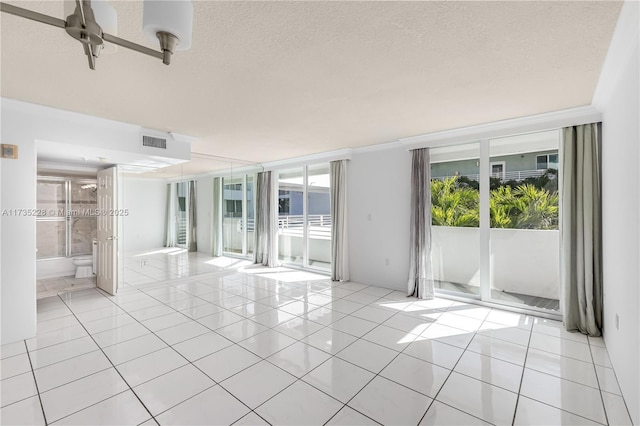 unfurnished room with a textured ceiling and light tile patterned floors