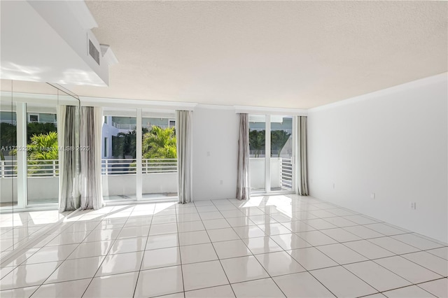 tiled spare room featuring crown molding, a wealth of natural light, and a textured ceiling