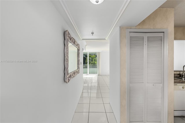 hall featuring ornamental molding, sink, and light tile patterned floors