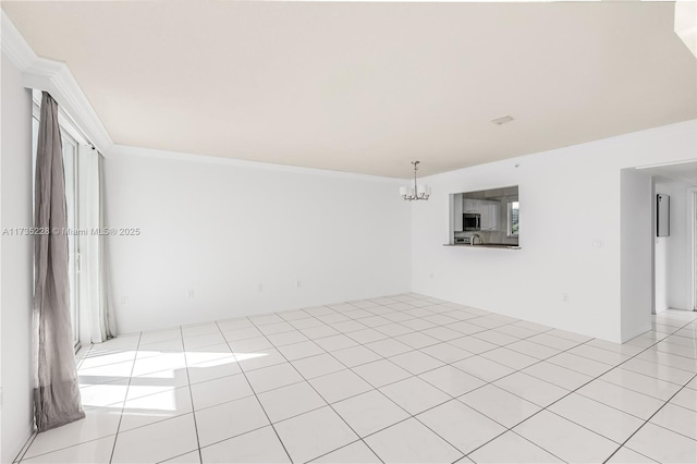 tiled empty room with crown molding and an inviting chandelier