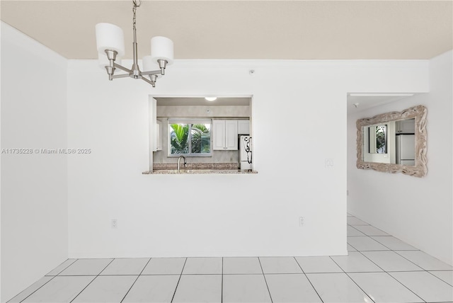 unfurnished dining area featuring sink, a chandelier, and light tile patterned flooring