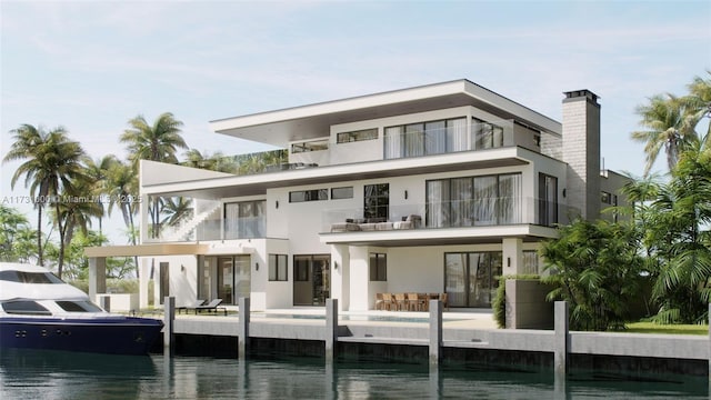 rear view of property with a chimney, a water view, and stucco siding