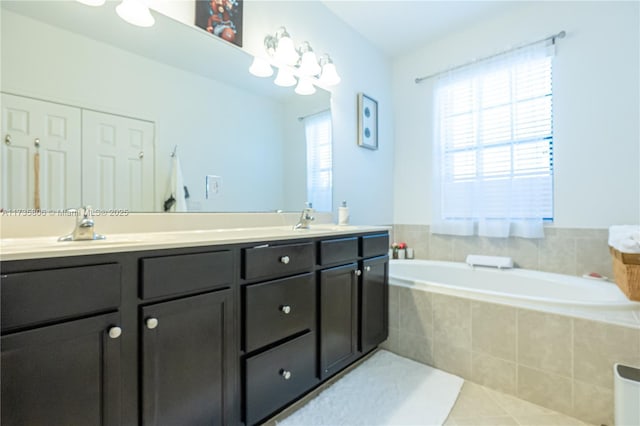 bathroom with tile patterned floors, vanity, and tiled tub