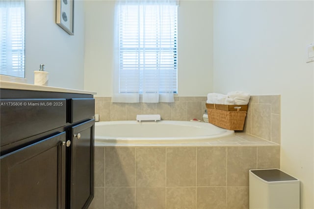 bathroom featuring a relaxing tiled tub and plenty of natural light