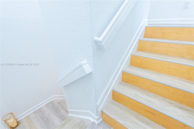 staircase with hardwood / wood-style floors