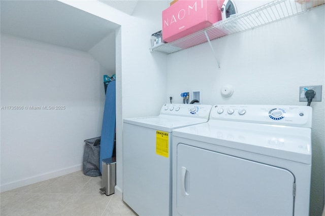 laundry room featuring light tile patterned floors and washer and clothes dryer