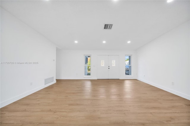 interior space with light wood-style flooring, visible vents, and baseboards