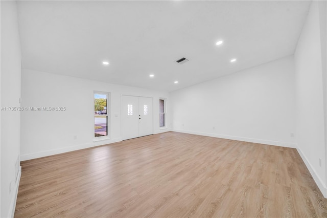 spare room featuring light wood-type flooring, baseboards, visible vents, and recessed lighting