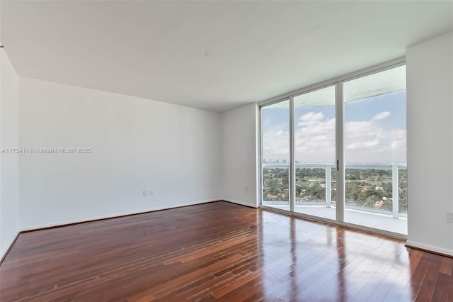 unfurnished room featuring dark hardwood / wood-style floors and expansive windows