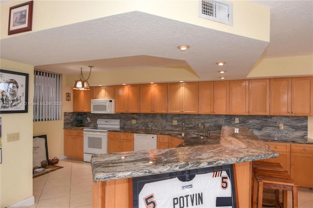 kitchen with light tile patterned flooring, sink, a kitchen breakfast bar, kitchen peninsula, and white appliances