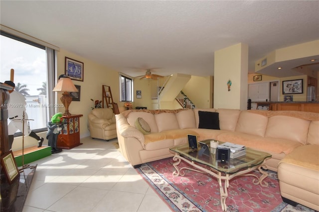 tiled living room with ceiling fan and a textured ceiling