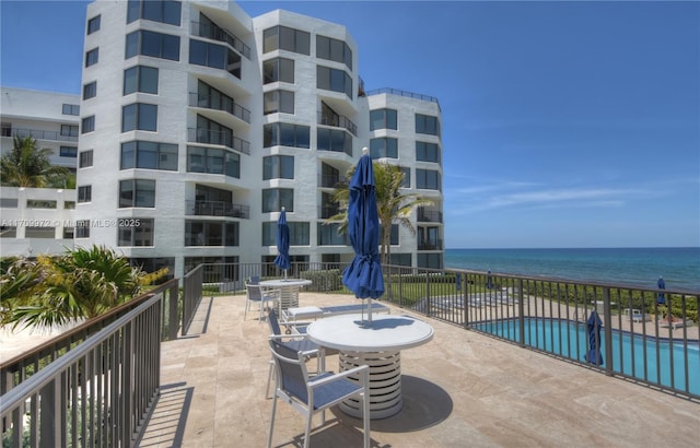 view of patio with a water view and a community pool