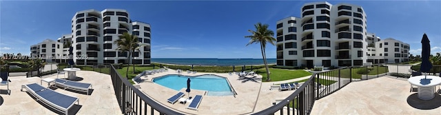 view of pool with a patio area and a water view