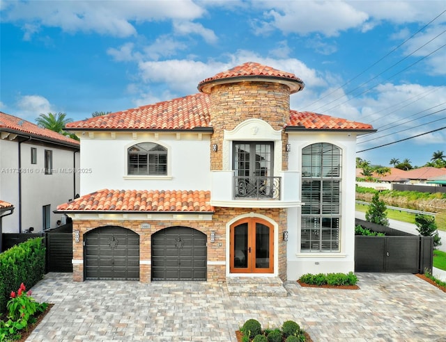 mediterranean / spanish-style house featuring a garage, a balcony, and french doors