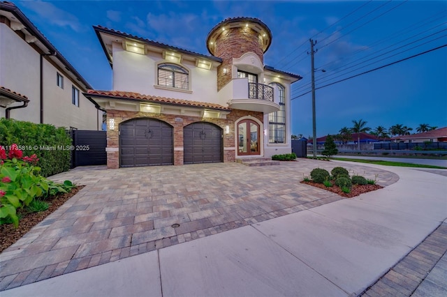 mediterranean / spanish-style home with a garage and a balcony