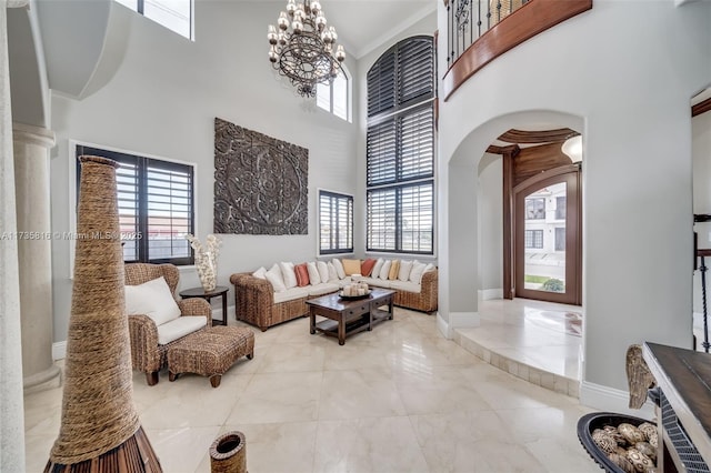 living room with an inviting chandelier, ornamental molding, and a high ceiling