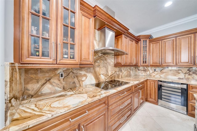 kitchen with wine cooler, ornamental molding, black electric stovetop, light stone counters, and wall chimney exhaust hood