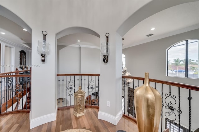 corridor featuring ornamental molding and wood-type flooring