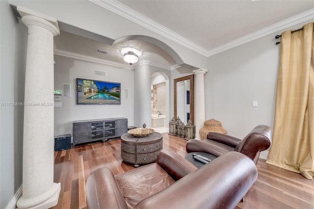 living room featuring ornate columns, wood-type flooring, and crown molding