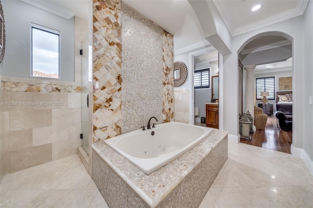 bathroom with crown molding, independent shower and bath, tile walls, and ornate columns